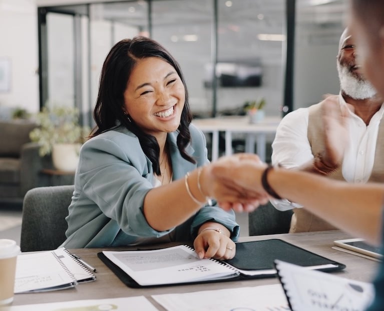 a woman shaking hands with a man in a suit