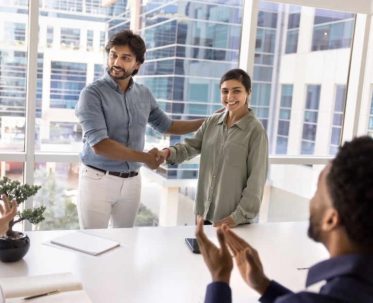 a man and woman shaking hands in a meeting room