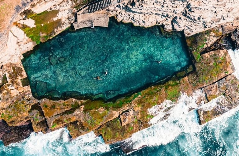 A historic ocean pool carved into the rocks, just a short drive from Marché Nude Stay.