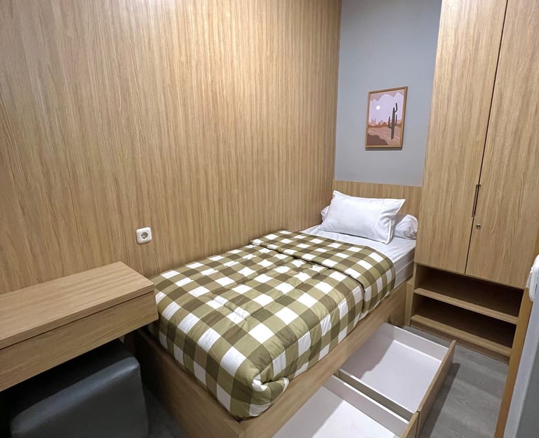Kamar kos premium di Kos Si Bos Surabaya Barat dengan tempat tidur single, meja belajar,  dan lemari