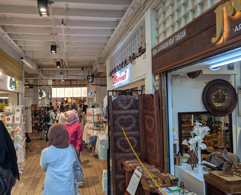 People browsing local artisan crafts and handmade souvenirs at The Central Market in Kuala Lumpur.