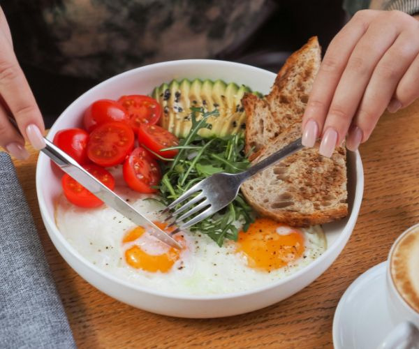 a person eating a bowl of food with a fork and fork