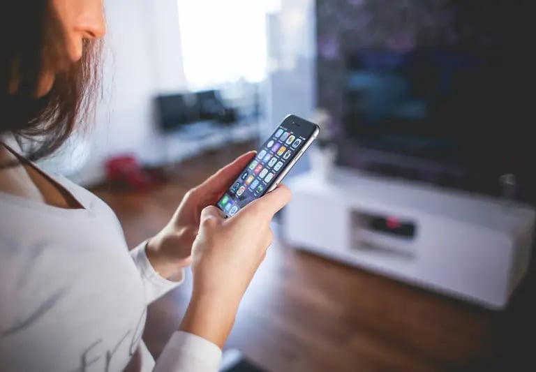 a woman holding a cell phone in her hand