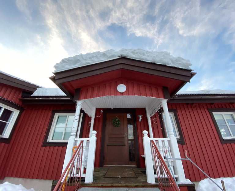 a red house with a red door and white stairs