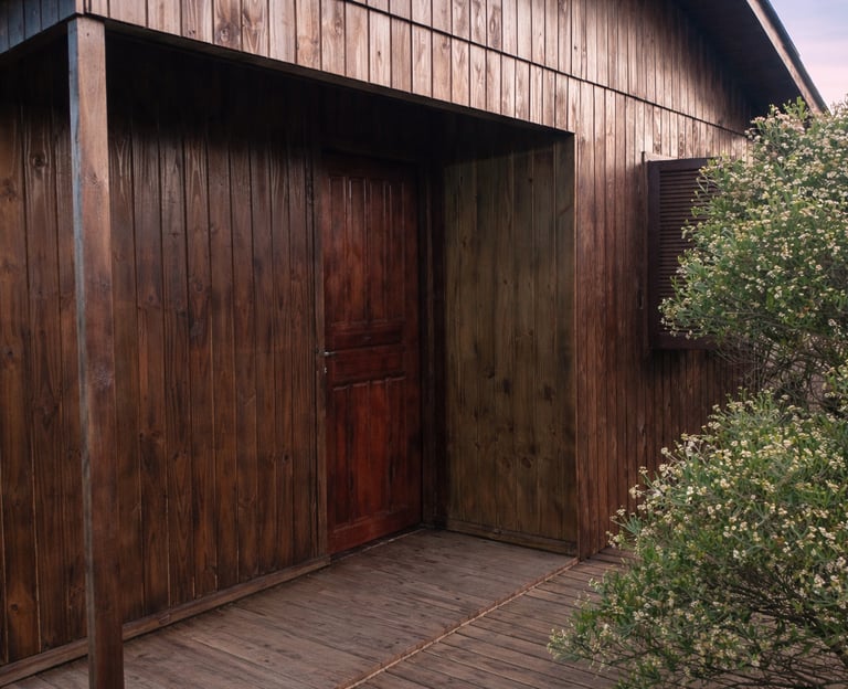 entrada da cabana familiar, de madeira e rústica, com árvores ao redor