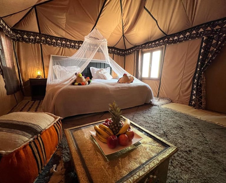 a bed with a canopy tented bed and a table with fruit on it