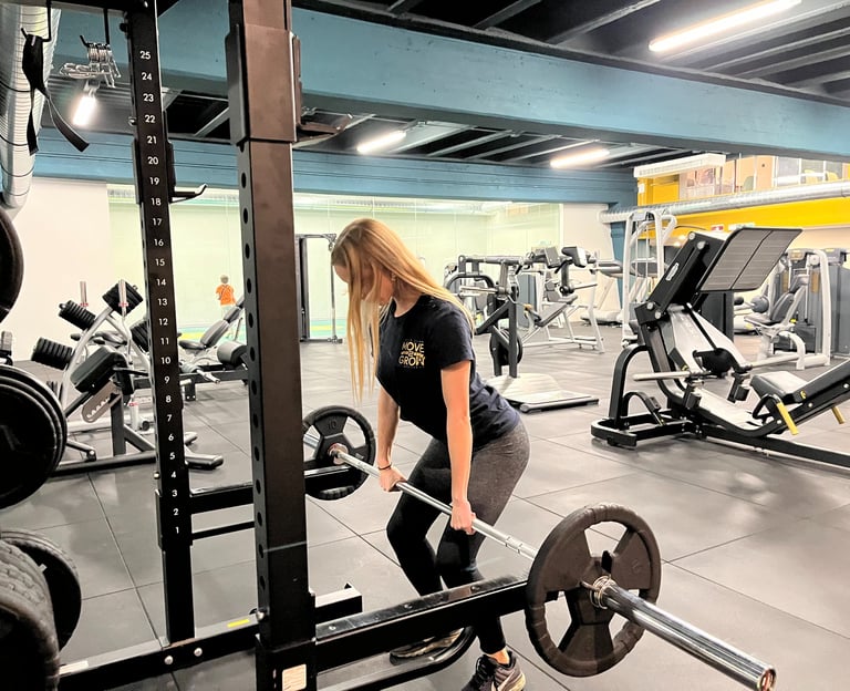 Istruttrice della palestra Move 2 Grow a Milano esegue esercizi di sollevamento pesi in un'area attrezzata per allenamento.