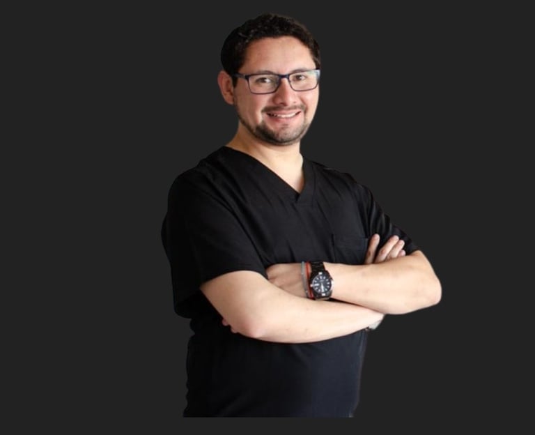 Smiling male healthcare professional in black scrubs and glasses posing with arms crossed.
