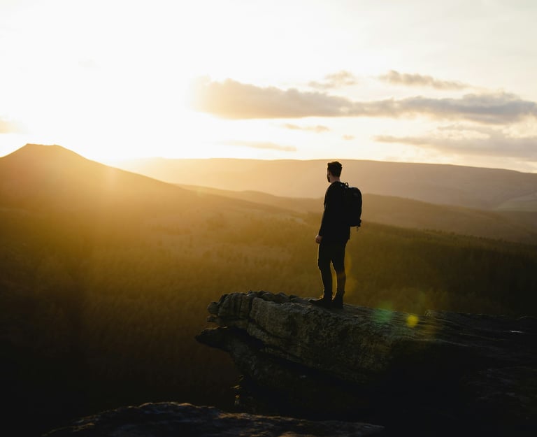 Man on a cliff representing a completed journey