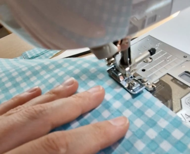 a person sewinging a piece of cloth