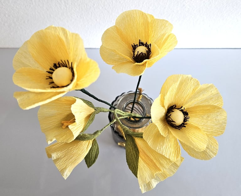 Dit boeketje is gemaakt van crepe papier en bestaat uit verschillende gele bloemetjes. Samen vormen ze een mooi geheel.