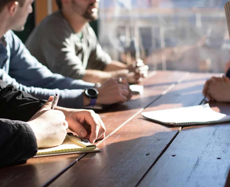 quatre hommes qui parlent autour d'une table