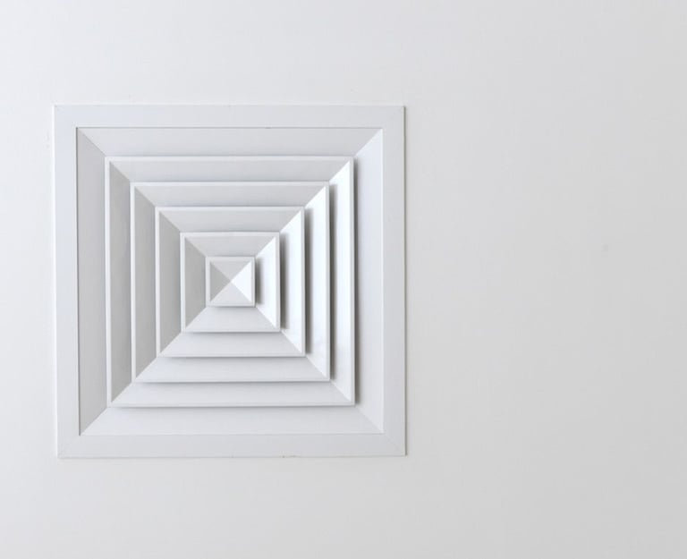 Grille de ventilation naturelle carrée au plafond, idéale pour une aération discrète et passive.