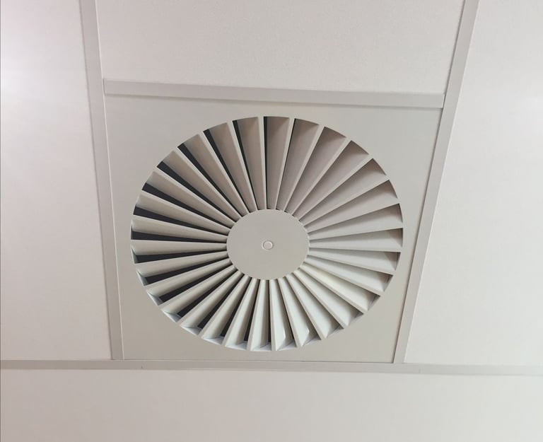 Grille de ventilation naturelle ronde intégrée au plafond, assurant un renouvellement d’air naturel.