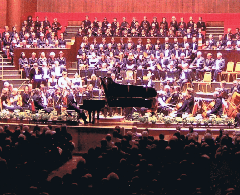 Photo of Steven Kings playing a grand piano in a concert hall