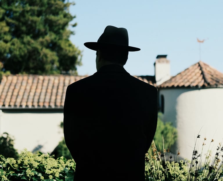 Film and TV production scene featuring a man in a hat under sunlight