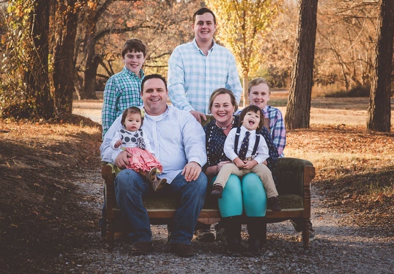 Foster Family sitting on a couch outside
