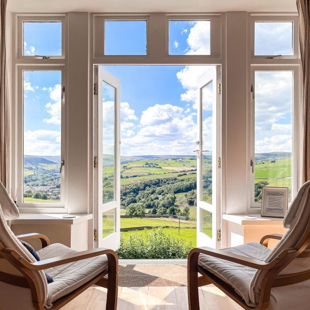 an open door looks out onto a countryside view