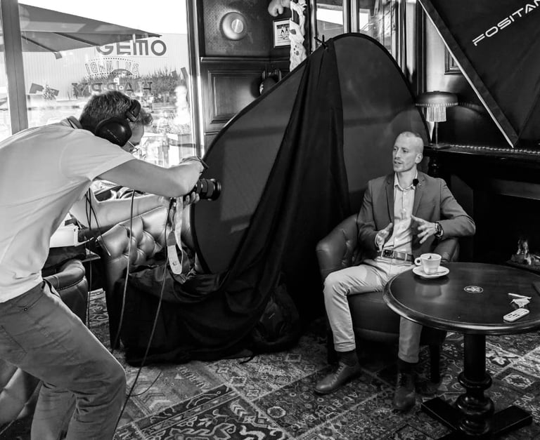 a man in a suit and tie is taking a photo of a man in a