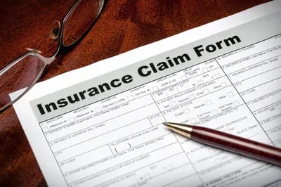 homeowners insurance claim form and a pen