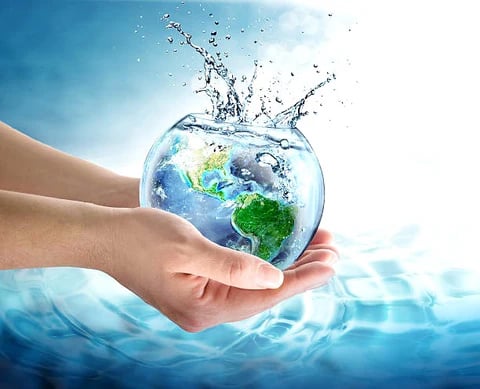 a person holding a fish bowl with water and a globe