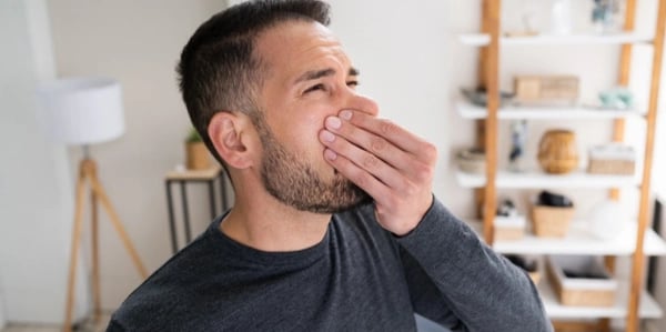man holding nose from sewer odor