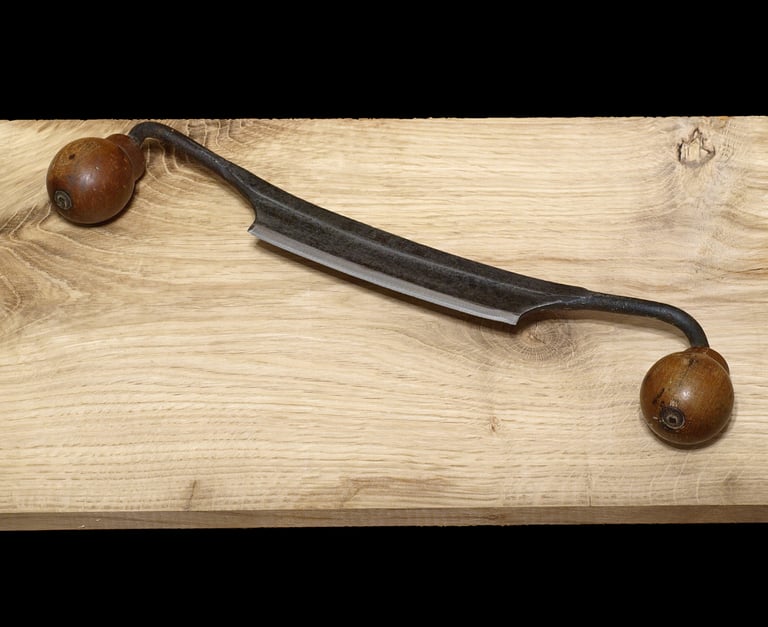 An old style drawknife on a wooden table