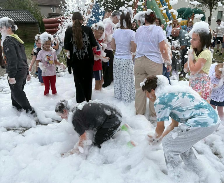 a group of people playing in a foamy foam filled with foam
