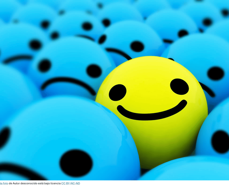 Imágenes que representan un rostro sonriente entre varios serios indicando que eres optimista