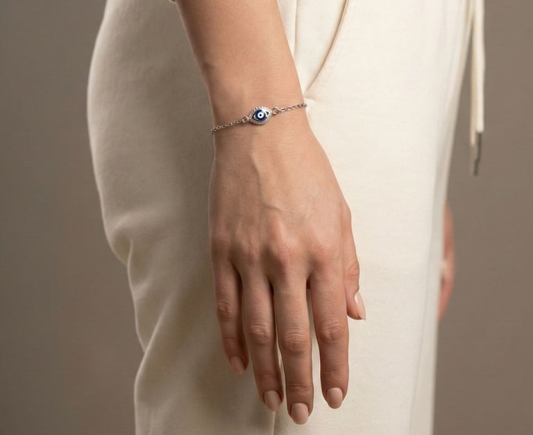 a woman's hand holding a bracelet with a evil eye