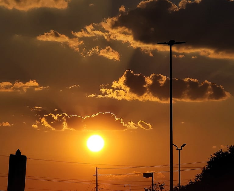 Yellow glowing sunrise with rays of sunlight shining through the clouds