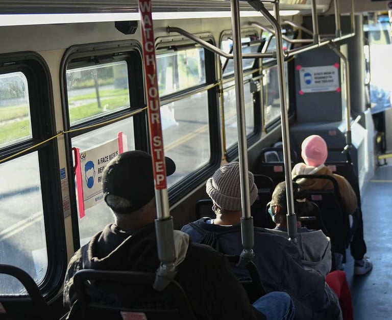 Photo of people on a bus from the back of the bus