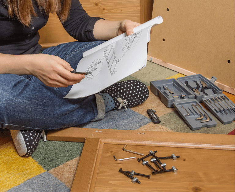 person reviewing instructions with tools scattered around
