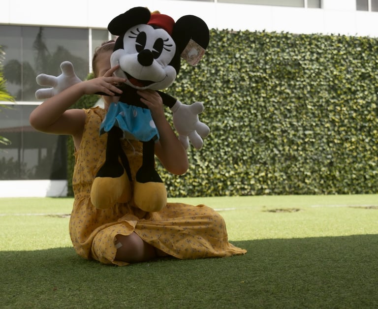 Niña jugando con su peluche de michey mouse