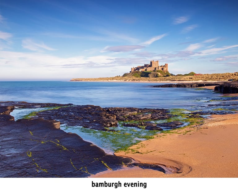 bamburgh castle on the beach in evening light