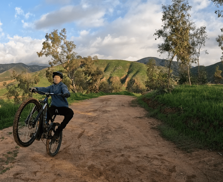 mountain biker practicing using rear brake to keep from looping out on wheelie