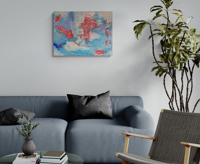 Blue and red artwork on wall above grey sofa.