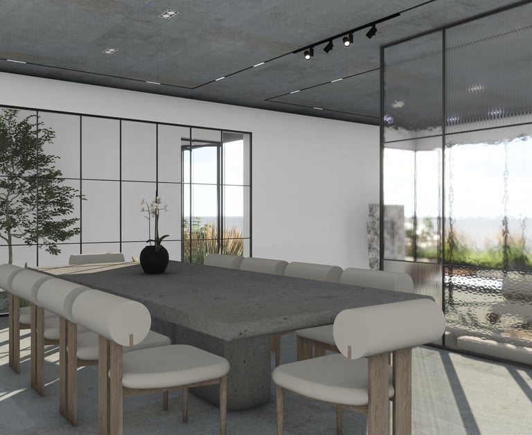 Large concrete dining table and modern chairs with light upholstery illuminated by track lighting