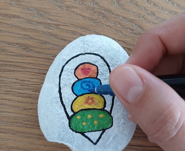 a person's hand holding a pen and drawing on a wanderstone