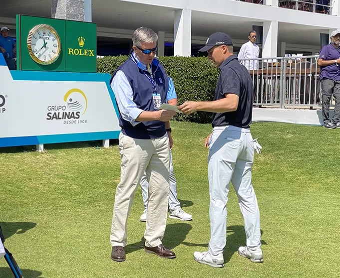 Casey handing Justin Thomas his scorecard.