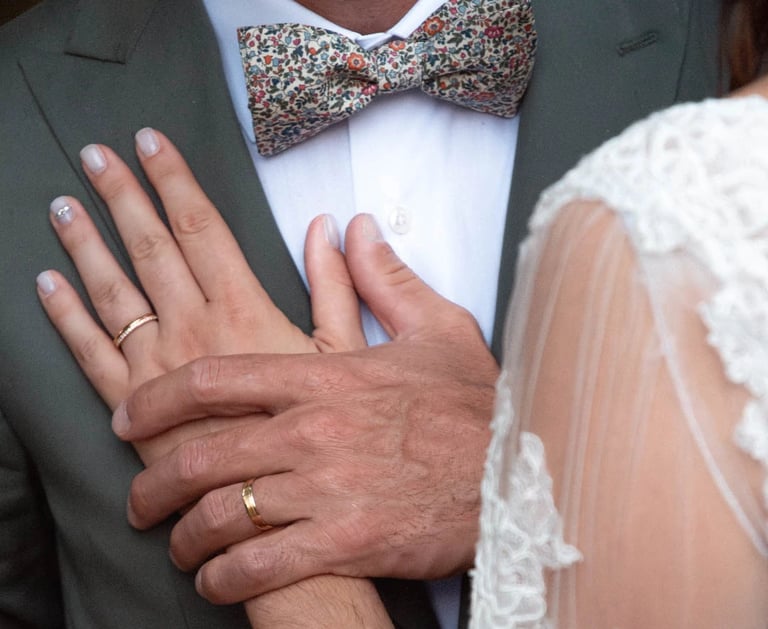 Les deux des mariées se tenant contre la poitrine de l'homme