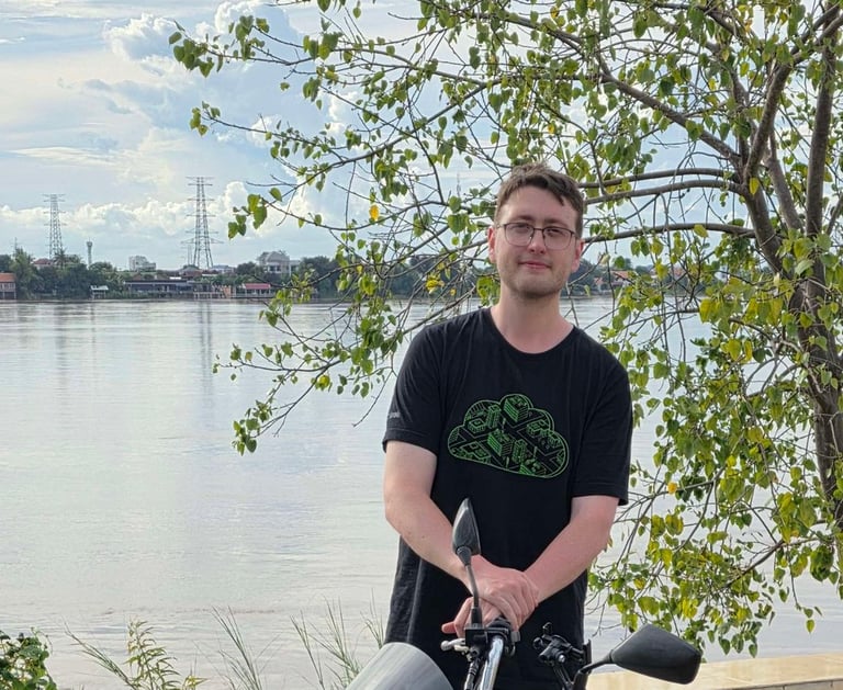 Jamie Blair beside a motorbike at the Mekong River in Phnom Penh, Cambodia