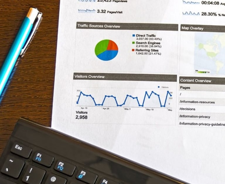 a analytics paper, keyboard and a pen on a desk 