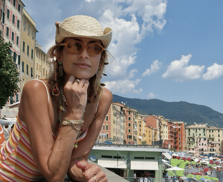 Mary Tornariti in straw hat at Camogli beach promenade, Liguria Italy.