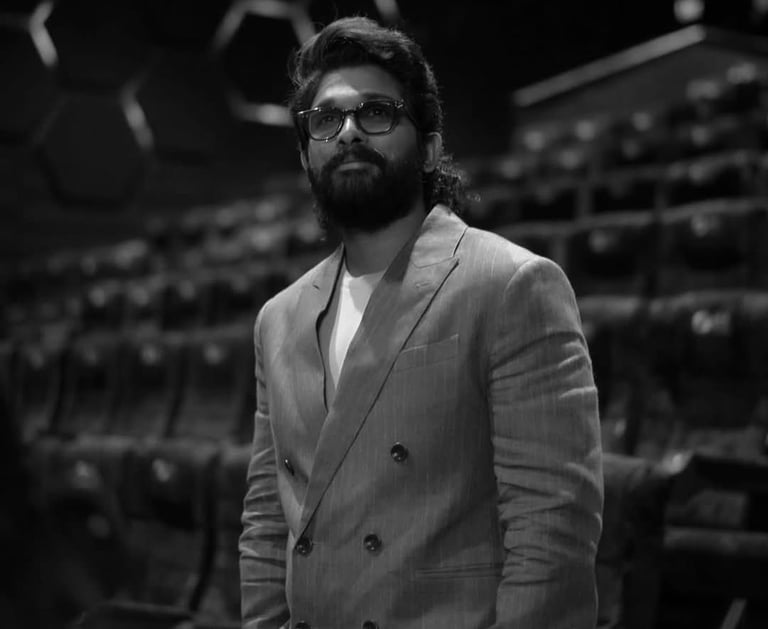 a man in a suit and glasses standing in a room
