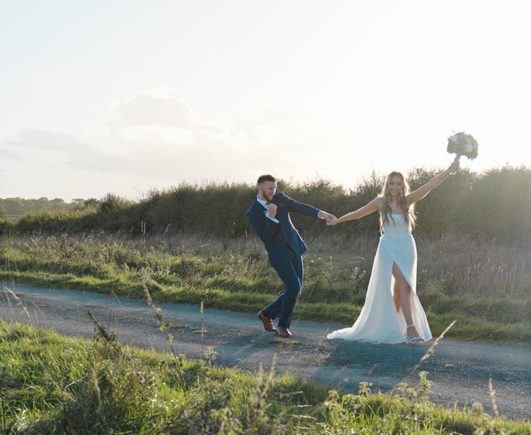 Bride and groom walking along celebrating getting married