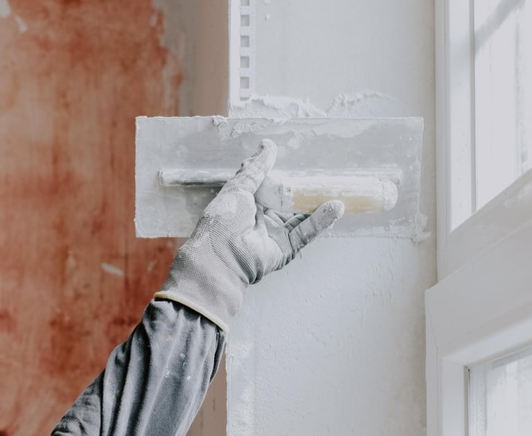 handyman applying plaster to repair an interior wall in an Auckland home