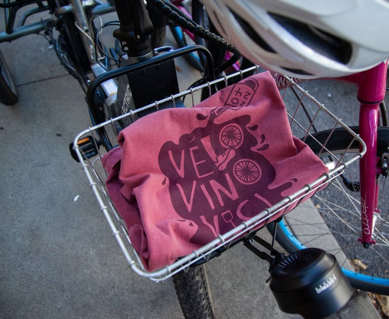 Photo of the Velo Vino Vici event T-Shirt, folded up sitting in a bike basket