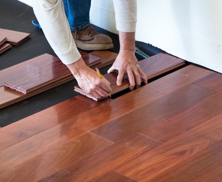 a person is holding a piece of wood flooring