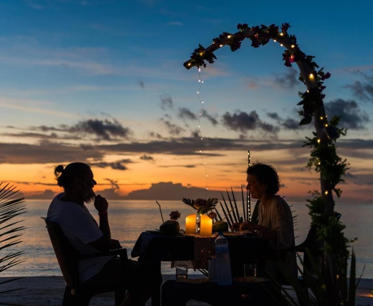 a couple sitting at a table with candles and candles